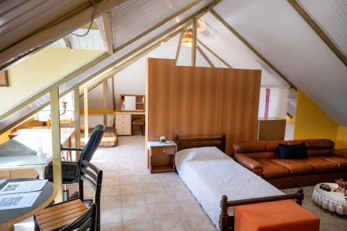 a attic room with a bed and a couch at Foothills loft in Keratea
