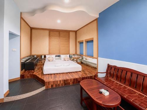 a hotel room with a bed and a couch at Suan Palm Garden View in Rayong