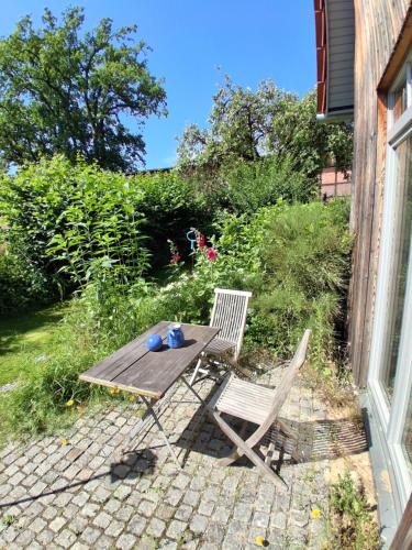 a picnic table and two chairs on a patio at hej atelier Ferienwohnung in Heiligenthal
