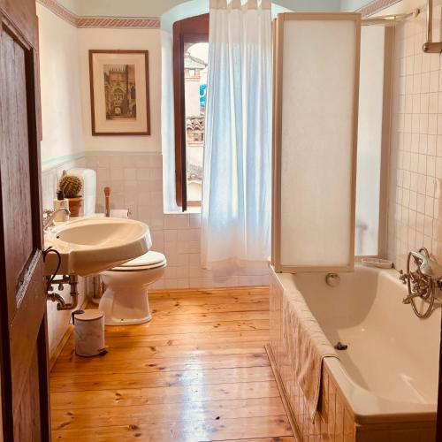a bathroom with a tub and a toilet and a sink at BaBi in Cison di Valmarino
