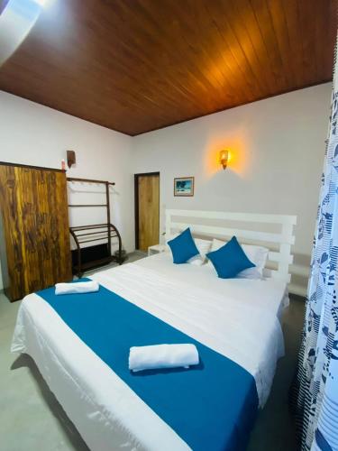 a bedroom with two beds with blue and white sheets at Green Villa Midigama in Midigama East