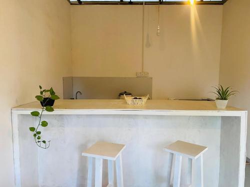 a counter with two stools in a room at Green Villa Midigama in Midigama East