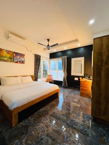 a bedroom with a bed and a large window at Villa Tesori Homestay Wayanad in Meppādi