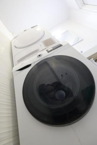 a white washing machine with a black door at Cozy Studio in Downtown Sesvete in Sesvete