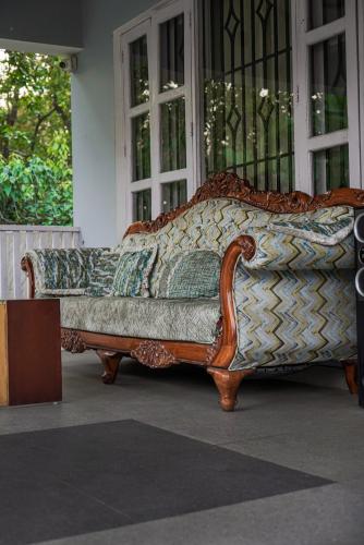 a couch sitting in front of a window at Kudrat Villa with Private Pool in Dehradun