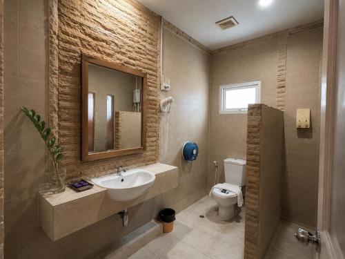 a bathroom with a sink and a toilet and a mirror at Suan Palm Garden View in Rayong