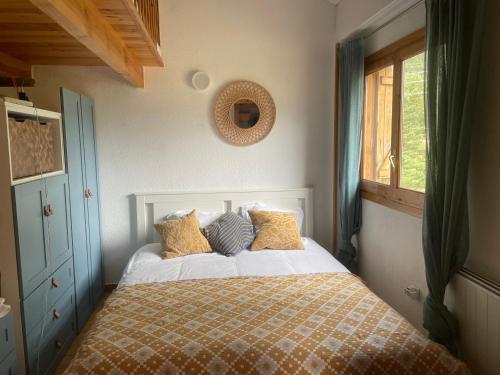 a bedroom with a bed with yellow and blue pillows at El rincón de la Rapeda in Villanúa