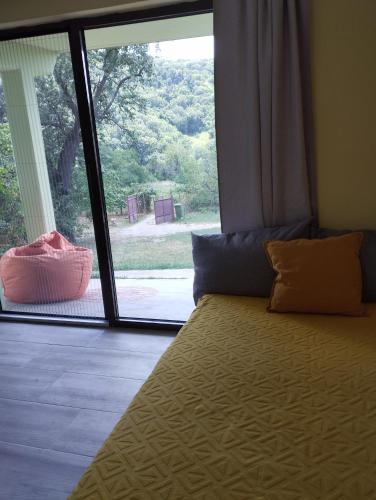 a bedroom with a bed with a large window at Iza sedam gora in Rakovac