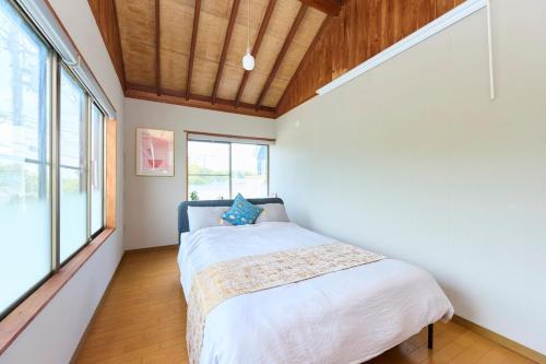 a bedroom with a bed and a large window at Miura Base in Miura