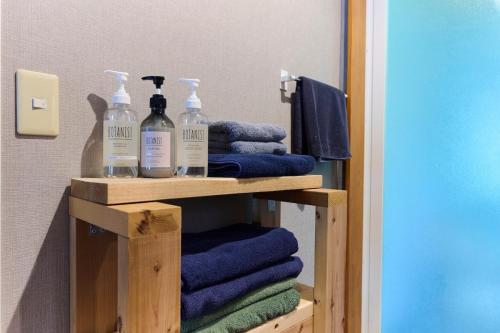 a bathroom with towels and bottles on a shelf at Miura Base in Miura