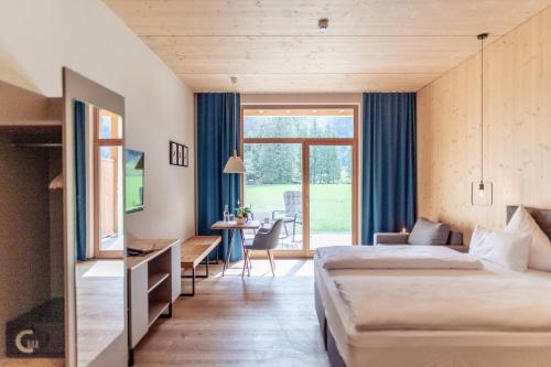a hotel room with two beds and a desk at Boutique Hotel LechZeit in Elmen