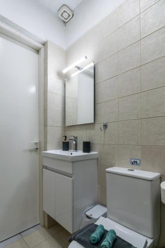 a bathroom with a sink and a toilet and a mirror at Paraspori in Adamantas