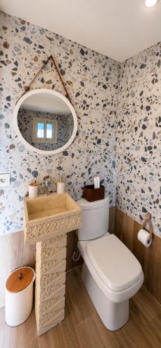 a bathroom with a toilet and a sink and a mirror at Olvaya in Bzîza