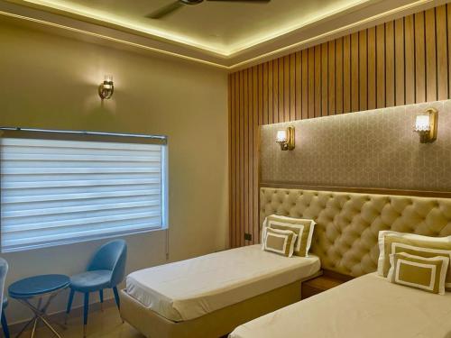 a room with two beds and a chair and a window at Shakti Resort in Behror