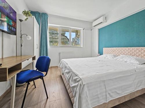 a bedroom with a bed and a desk and a blue wall at Konstanzer Stefan 15 - Old Town Apt - Palas Mall - AC in Iaşi
