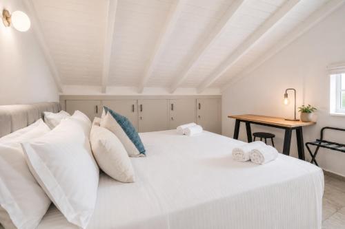 a bedroom with a white bed and a table at Luminis Residence by All about Paxos in Gaios
