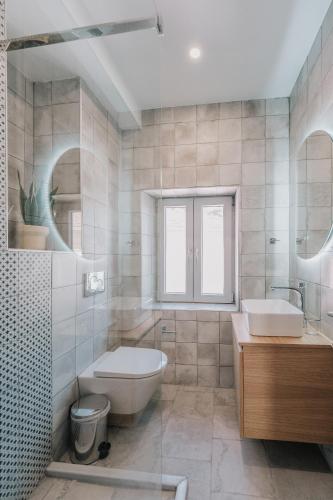 a bathroom with a sink and a toilet and a tub at Luminis Residence by All about Paxos in Gaios