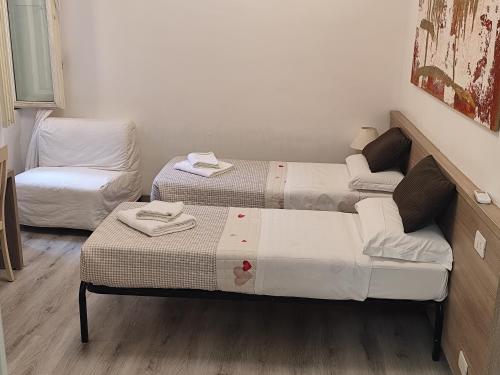 two beds in a room with a couch and a chair at Art And Relax Suites in Rome
