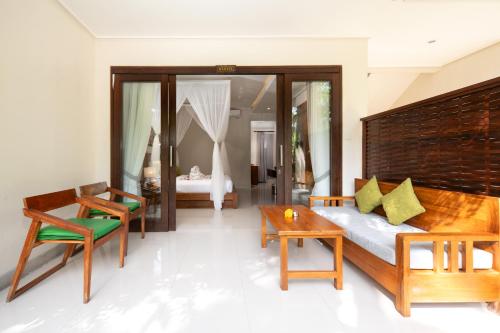 a bedroom with a bed and a table and chairs at Ubud Tropical Garden in Ubud
