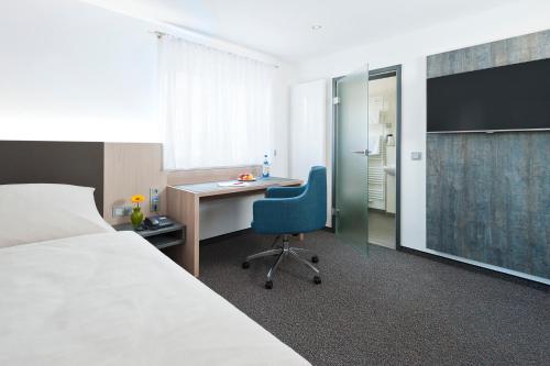 a hotel room with a desk and a bed at Hotel Käferstein garni in Nürnberg