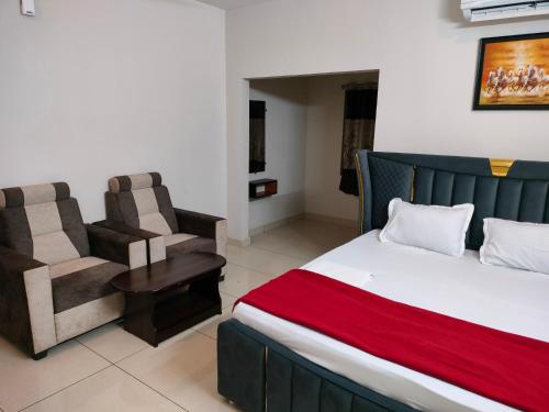 a hotel room with a bed and a chair at Royal Residency in Vākalapūdi
