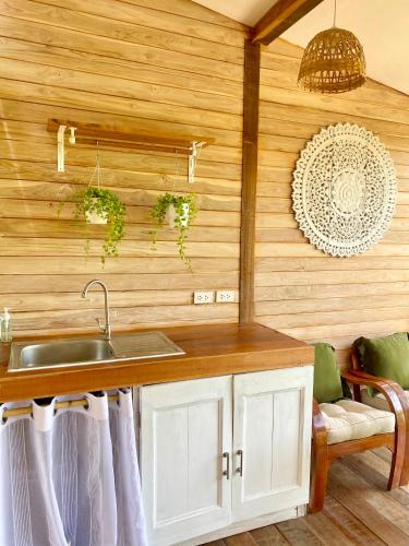 a kitchen with a sink and a wooden wall at Kalulushi Bungalows in Haad Pleayleam