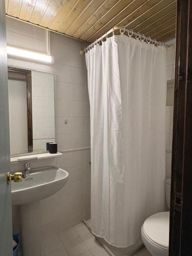 a bathroom with a shower curtain and a sink at Skala Apartments in Agia Marina Nea Kydonias