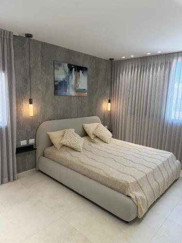 a bedroom with a large bed with curtains at Nitza 14 in Netanya
