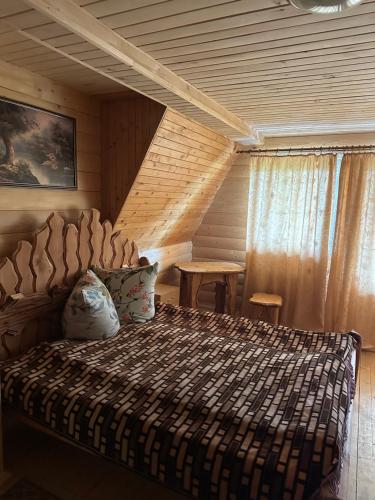 a bedroom with a bed and a table in it at River Side Retreat in Slavske