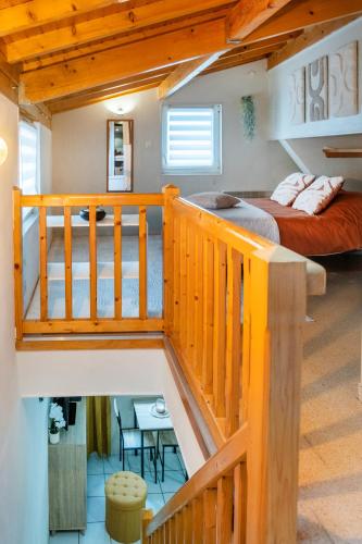 a bedroom with a staircase and a bed in a room at le duplex de l'Hôtel de ville in Lourdes