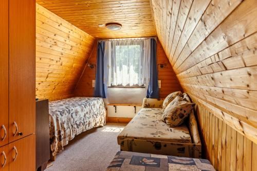 a small bedroom with a bed and a window at Chatka Jitka kytka in Jedovnice