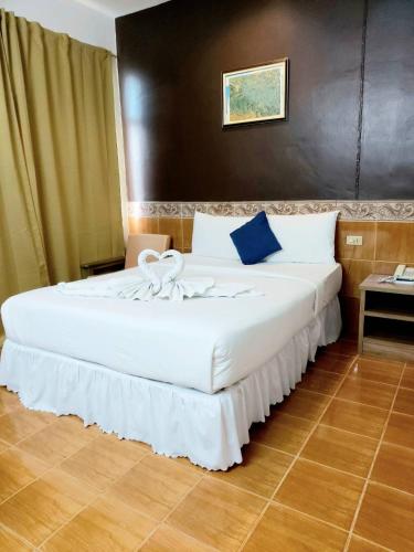 a hotel room with a large bed with white sheets at Suriwong Chumphon Hotel in Chumphon