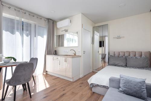 a bedroom with a bed and a table and a kitchen at 4rest in Palanga
