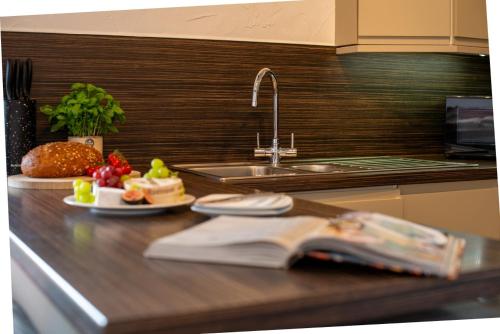 a kitchen counter with a sink and a book at Braddon - Treworgie Barton Cottages in Bude