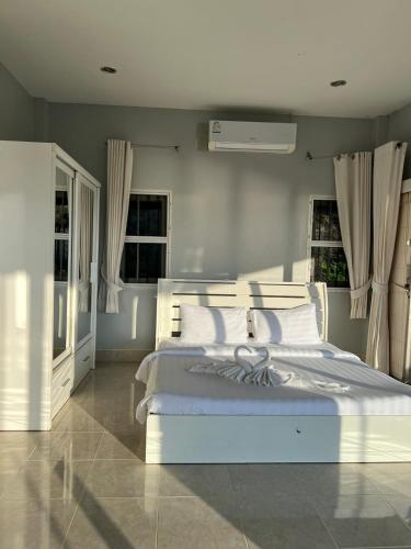 a bedroom with a large white bed with white pillows at The Sunset Suite Panoramic Sea Views in Sikao