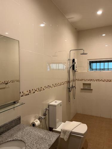 a bathroom with a toilet and a sink and a mirror at The Sunset Suite Panoramic Sea Views in Sikao