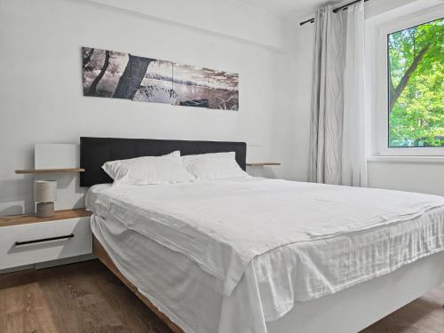 a white bedroom with a bed and a window at Konstanzer 3 - Spacious 2-Room Apt - Iulius Mall in Iaşi