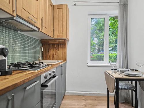 a kitchen with wooden cabinets and a table and a window at Konstanzer 3 - Spacious 2-Room Apt - Iulius Mall in Iaşi