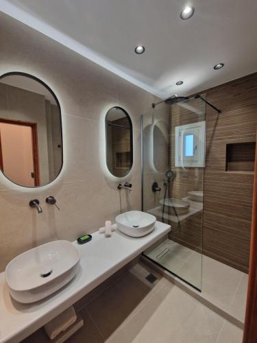 a bathroom with two sinks and a shower at Filoxenia Studios in Kithnos