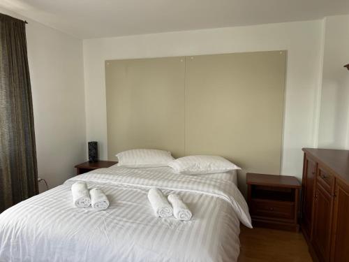 a bedroom with a bed with white slippers on it at Casa Larisa Borsa in Borsa