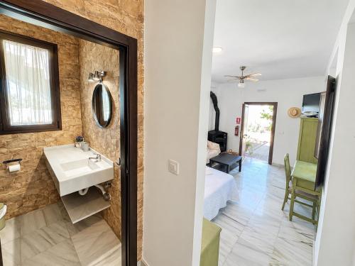 a bathroom with a sink and a bed in a room at Cortijo Domínguez - Rural Experience in Lucena