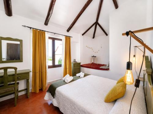 a bedroom with a bed and a desk and a window at Cortijo Domínguez - Rural Experience in Lucena