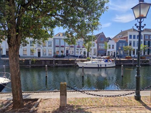 a boat is docked in the water next to buildings at Boutique Hotel De Grote Kade in Goes