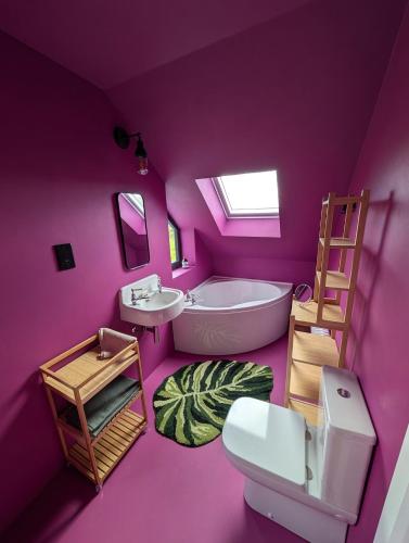 a purple bathroom with a bath tub and a sink at Lon Godrum in Kingsburgh
