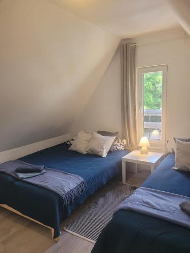 a bedroom with two beds and a window at LEŚNA OSTOJA in Rewal