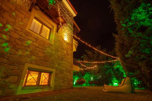 a building with christmas lights on the side of it at The Garden House in Siviri