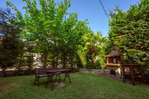 a picnic table and a grill in a yard at The Garden House in Siviri