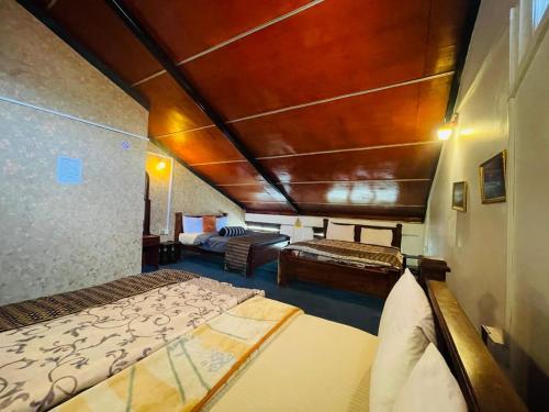 a bedroom with two beds and a couch in a room at Himawari Hills Hostels in Nuwara Eliya