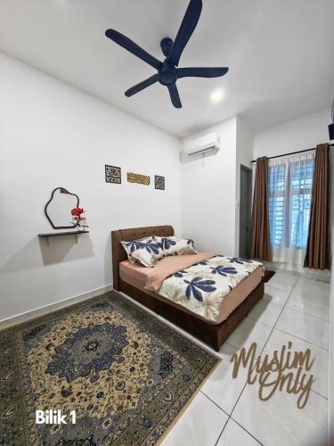 a bedroom with a bed and a ceiling fan at Homestay Seri Damai in Juasseh