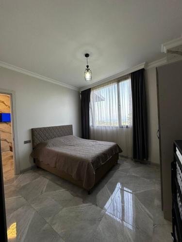 a bedroom with a bed and a large window at Golden Horizon in Ts'ikhisdziri